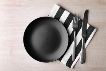 Empty plate with silver fork and knife on wooden background - Powered by Adobe
