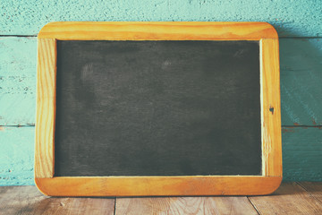 vintage wooden blackboard on wooden table with space for text