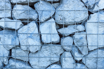 Folded large colored stones and reinforced wire mesh. Background.