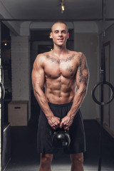 Fototapeta na wymiar Tattooed shirtless man holds lifting weight.