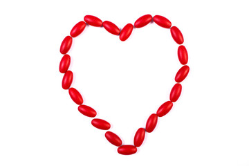 Heart shaped red medical pills and capsules, health care concept