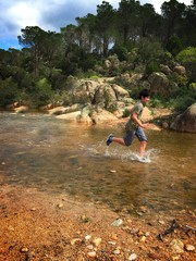 Young boy running into the water