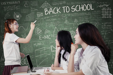 Girl explaining a lesson at her friends