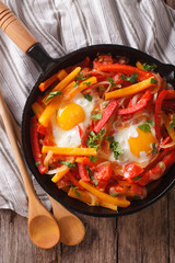 Basque breakfast: fried eggs with peppers close-up. vertical top view
