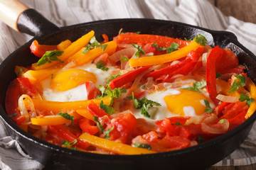 breakfast: fried eggs with peppers in a pan close-up. horizontal
