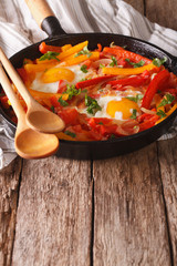 Typical Basque piperada with eggs in a frying pan. vertical

