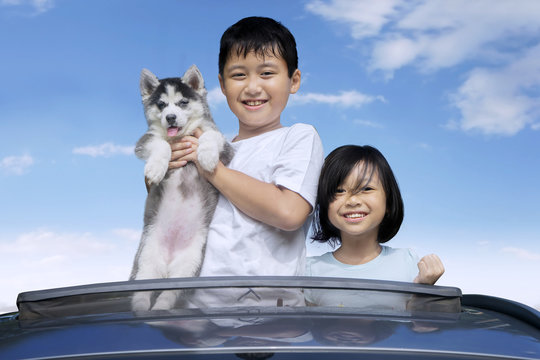 Kids And Husky Puppy On The Sunroof