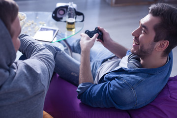 Attractive young guys are playing video game © Yakobchuk Olena