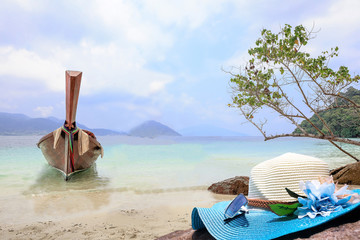 Fototapeta na wymiar blue hat and sunglasses on stone with sea view have a big wood b