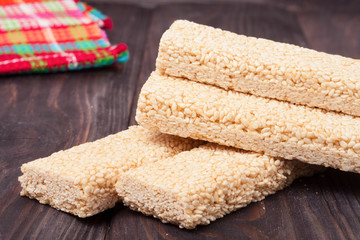 Honey bars with sesame seeds on wooden background