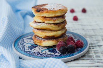ruddy cheesecakes with powdered sugar and berries.