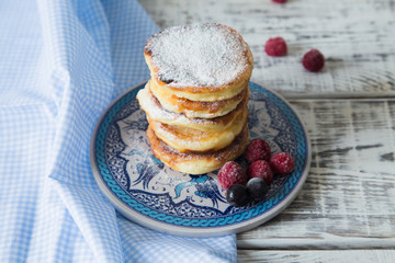 ruddy cheesecakes with powdered sugar and berries.