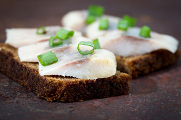 Sandwiches of rye bread and herring. Pieces of fish are herring