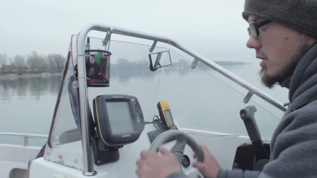 A fishing vessel uses a sonar device to find fish. the fisherman, the driver motor boat looking for fish, looking at sonar and depth finder