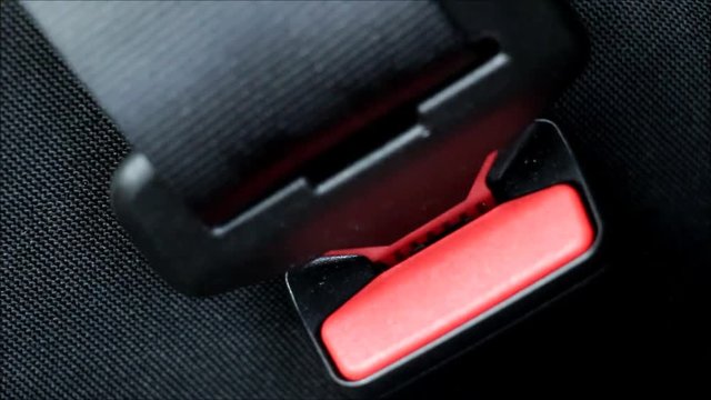Man fastens the seat belt in the car