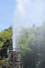 Plakat 峰温泉大噴湯公園。東洋一を誇る静岡県賀茂郡河津町・峰温泉の大噴湯です。大正15年11月22日正午に誕生、以来ひとときも絶えることなく噴き上げ続けています。毎分600リットル・100℃の温泉が高さ30mまで噴き上がる自噴泉です。入園無料。1日7回噴き上がります。火曜・金曜はメンテナンスの為定休日となっております。