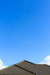 Fototapeta na wymiar black tile roof on a new house with clear blue sky background