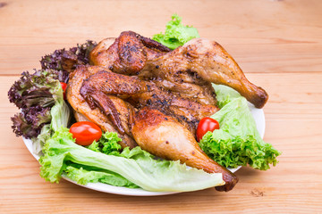 Juicy grilled roast chicken with herb, lettuce and tomato garnish 
