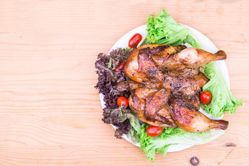Juicy grilled roast chicken with herb, lettuce and tomato garnish 
