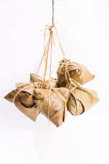 Bunch of Chinese rice dumpling tied hanging on vertical format against white background