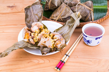 Unwrapped steamed Chinese rice dumpling or zongzi served with oriental tea