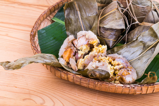 Closeup on unwrapped steamed Chinese rice dumpling or zongzi served with oriental tea