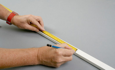 Handyman measuring surface mount plastic electric wiring channel
