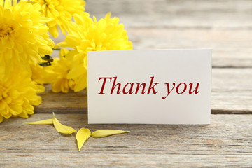 Naklejka premium Yellow chrysanthemum flowers on a grey wooden table