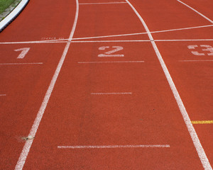 Rote Tartanbahn mit Startnummern in einem Station
