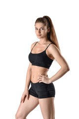 Obraz premium Cutout fitness woman in shorts and a tank top standing sideways