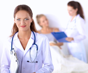Fototapeta premium Smiling female doctor with a folder in uniform standing at hospital
