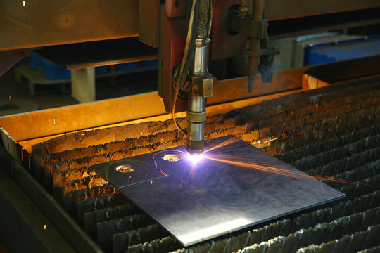 Industrial cnc plasma cutting of metal plate. Closeup