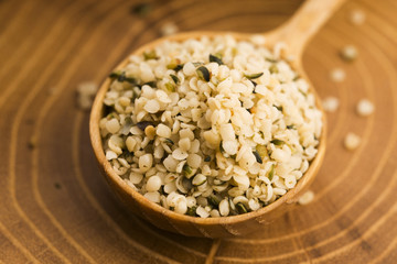 Shelled hemp seeds on wood background
