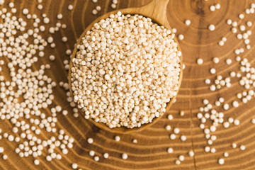 White quinoa seeds on a wooden background
