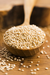 White quinoa seeds on a wooden background