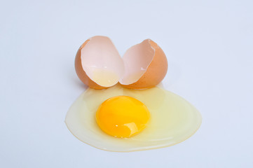 Broken egg with yolk, isolated on white background.