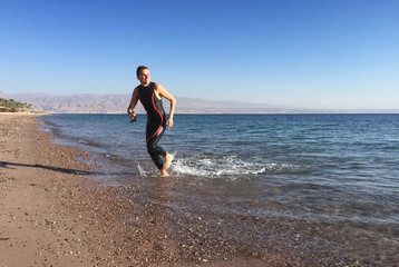 Professional triathlete practicing in open water. Swimming in se