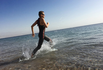 Professional triathlete practicing in open water. Plunge in sea.