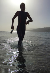 Professional triathlete practicing in open water. Swimming in se