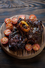 Close-up of osso buco served with baked cherry tomatoes