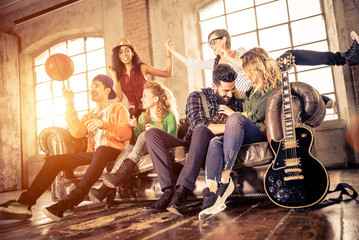 Mixed race group having fun on the couch in a loft