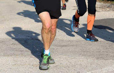 Fototapeta na wymiar two runners run on asphalt road uphill while running outdoors