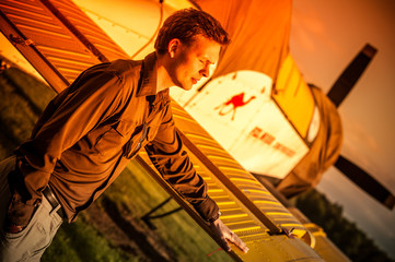 Outdoor portrait of attractive man at airport with vintage old propeller plane in Rybnik Gotartowice Poland