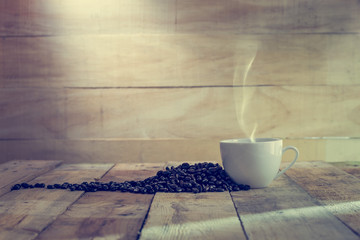 cup of coffee and beans over wood background