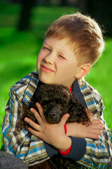 boy with a black poodle on a green background