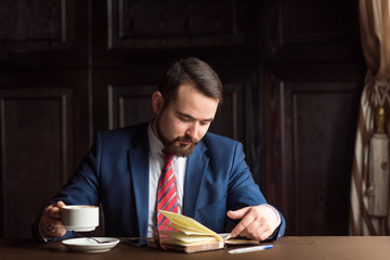 businessman or writer, making notes in his diary notebook