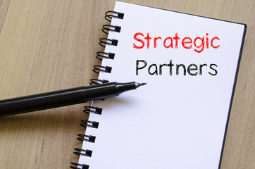 Strategic partners write on notebook