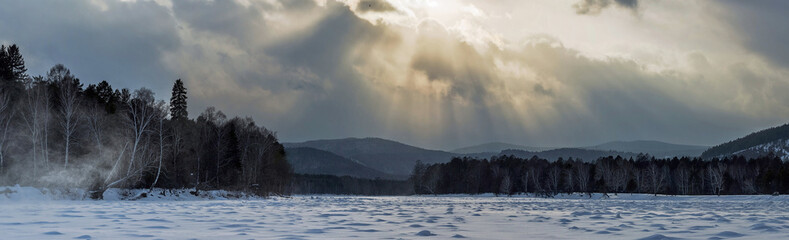Fototapeta premium Light from the clouds over the river Irkut