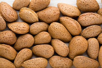 Group of almond nuts with leaves.Wooden background.