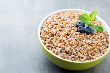 Buckwheat porridge in a bowl with mint leaves and blueberries.
